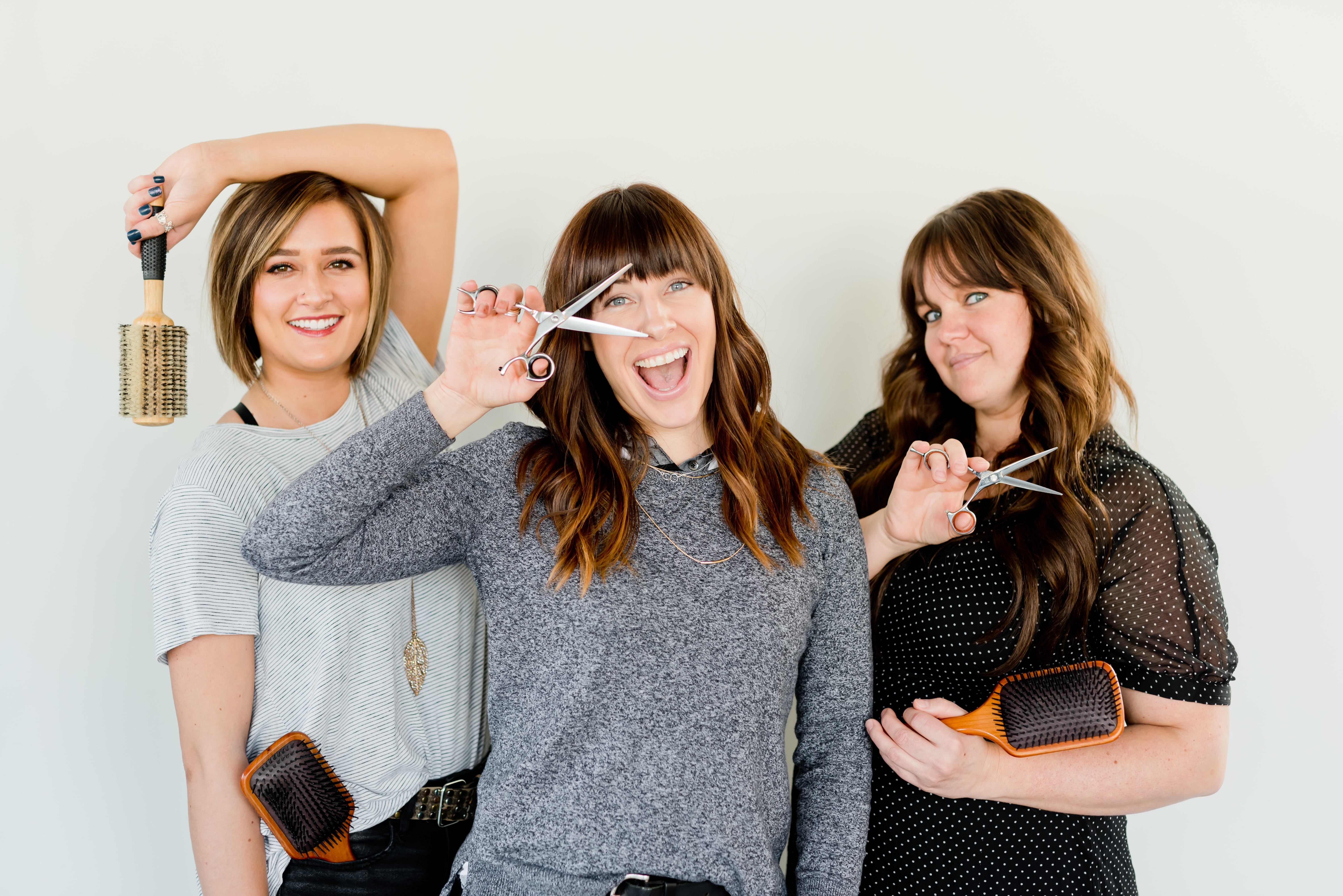 Three women being silly with haircutting tools